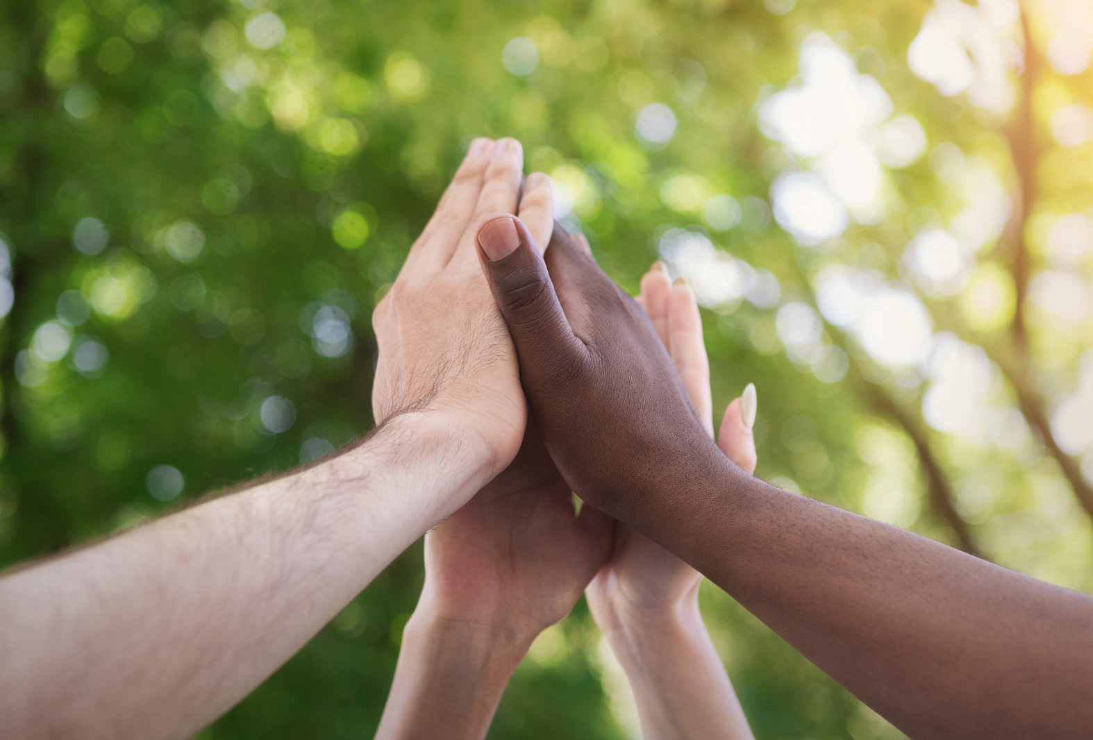 Business team giving group high five in park
