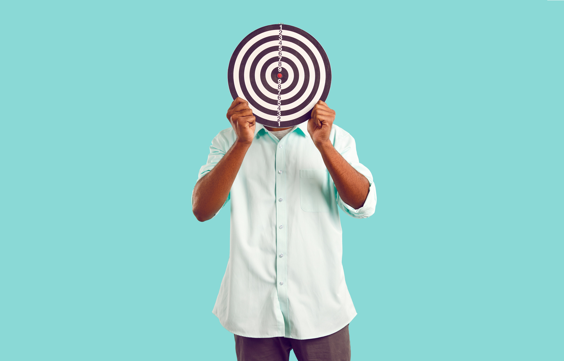 Anonymous Man Hides Face behind Dart Board, Symbolizing Selection of Target Audience or Targeted Ads